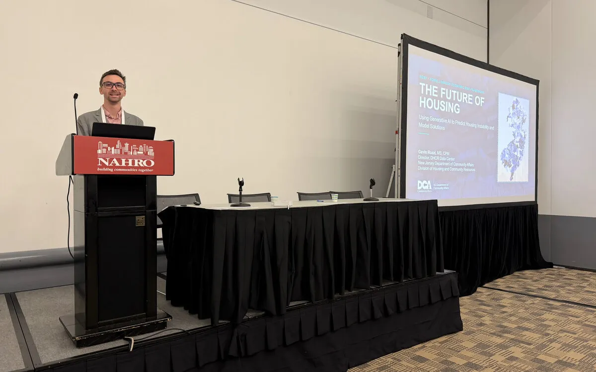 Gavin Rozzi at the NAHRO podium at the Colorado Convention Center in Denver, with the HERF title slide, The Future of Housing, projected on the screen beside him.