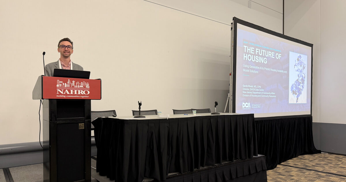 Gavin Rozzi at the NAHRO podium in Denver beside a projected title slide reading The Future of Housing: Using Generative AI to Predict Housing Instability and Model Solutions.